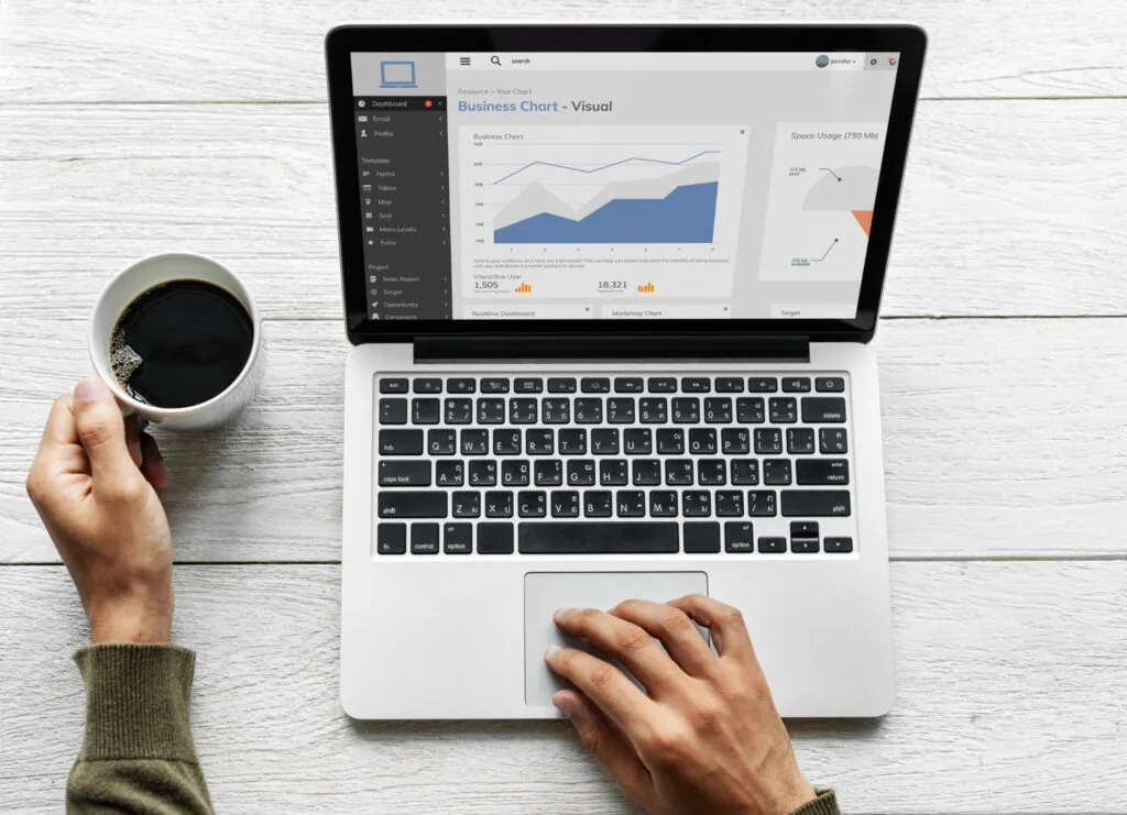 Pessoa conferindo dados de google analytics no notebook